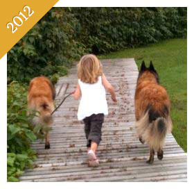 Same child walking same dog on boardwalk from 2012