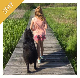 Same child is now a preteen walking same dog on boardwalk from 2017