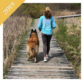 Same preteen walking same dog on boardwalk from 2019